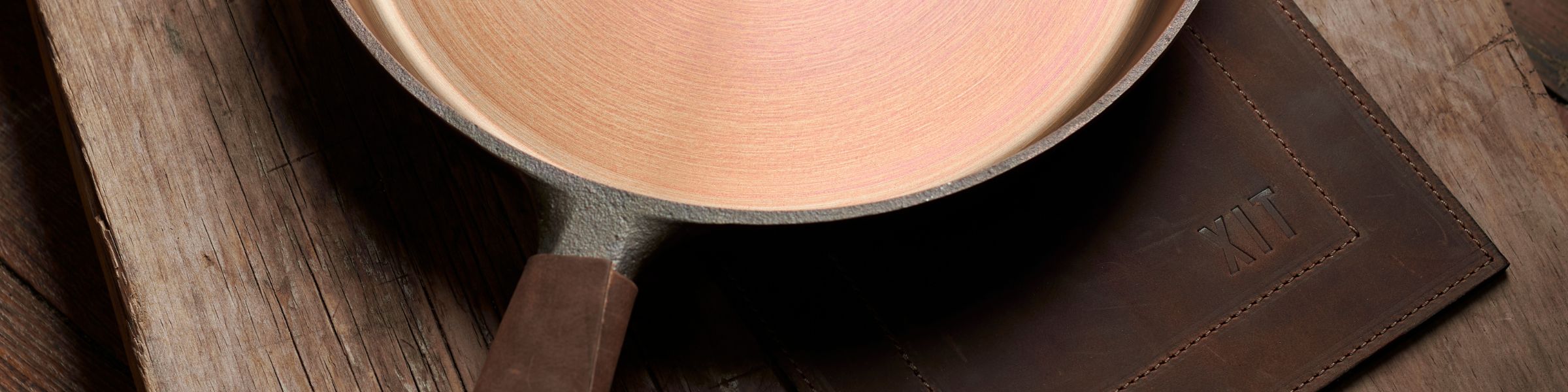 Cast iron pan with a XIT leather handle cover and a XIT leather trivet